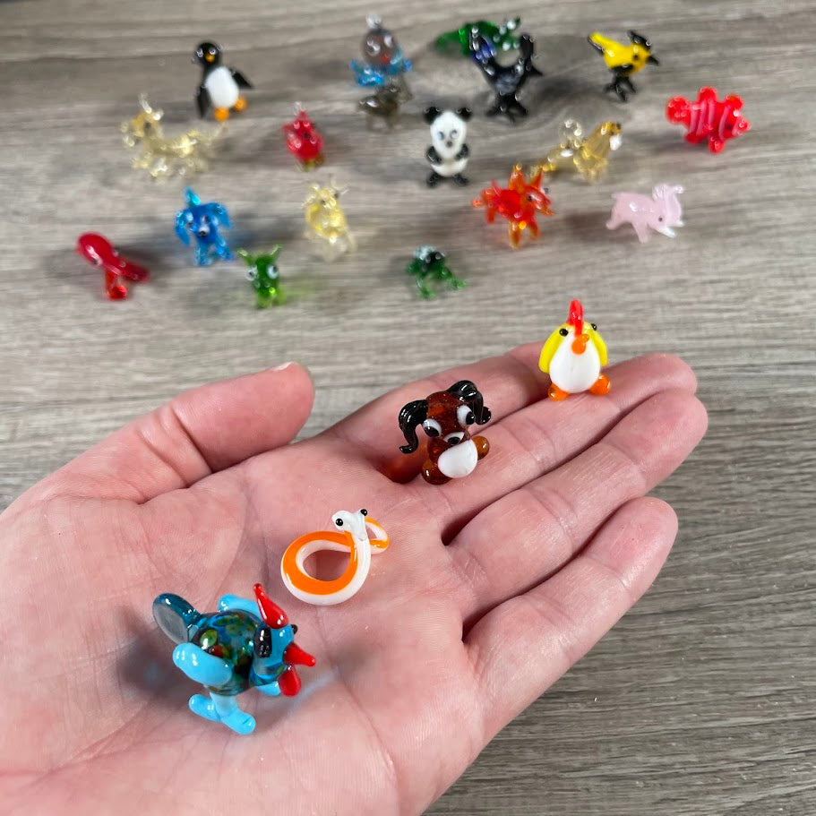 Assorted small glass animal figurines displayed, ideal for gift shops 