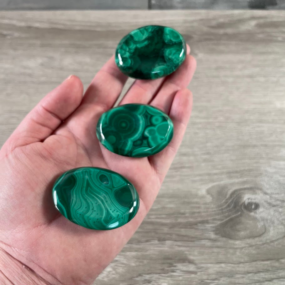 Polished malachite worry stone with natural green banding