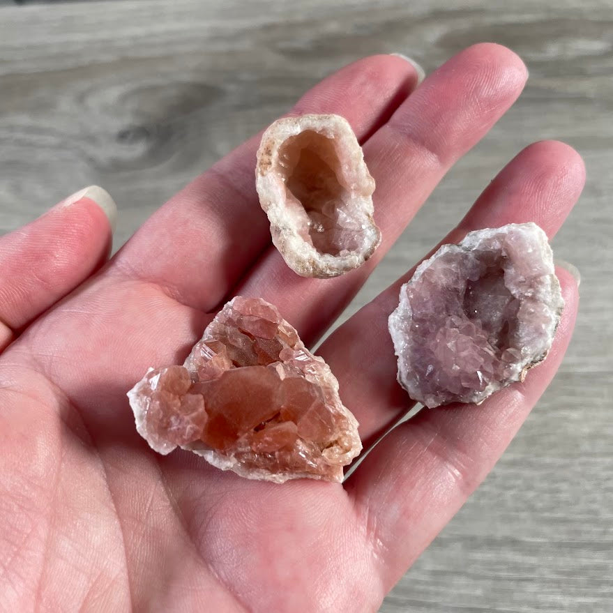 Small pink amethyst crystal points with natural sparkle and earthy mineral patterns