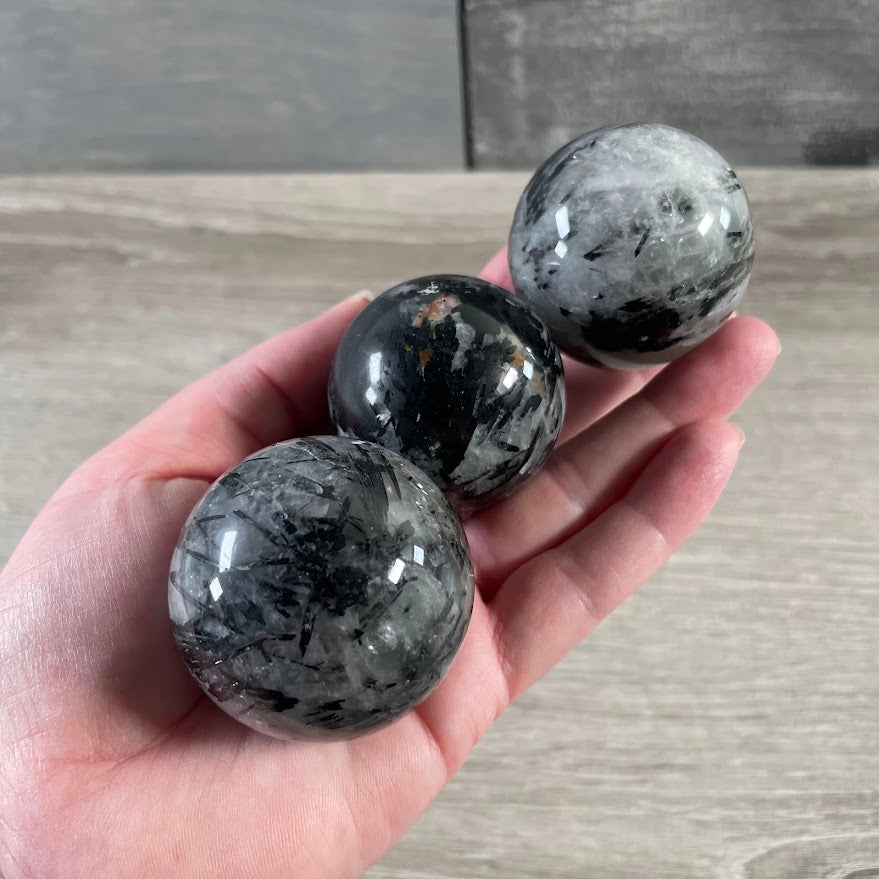 Tourmalinated quartz sphere with black tourmaline inclusions in polished clear quartz