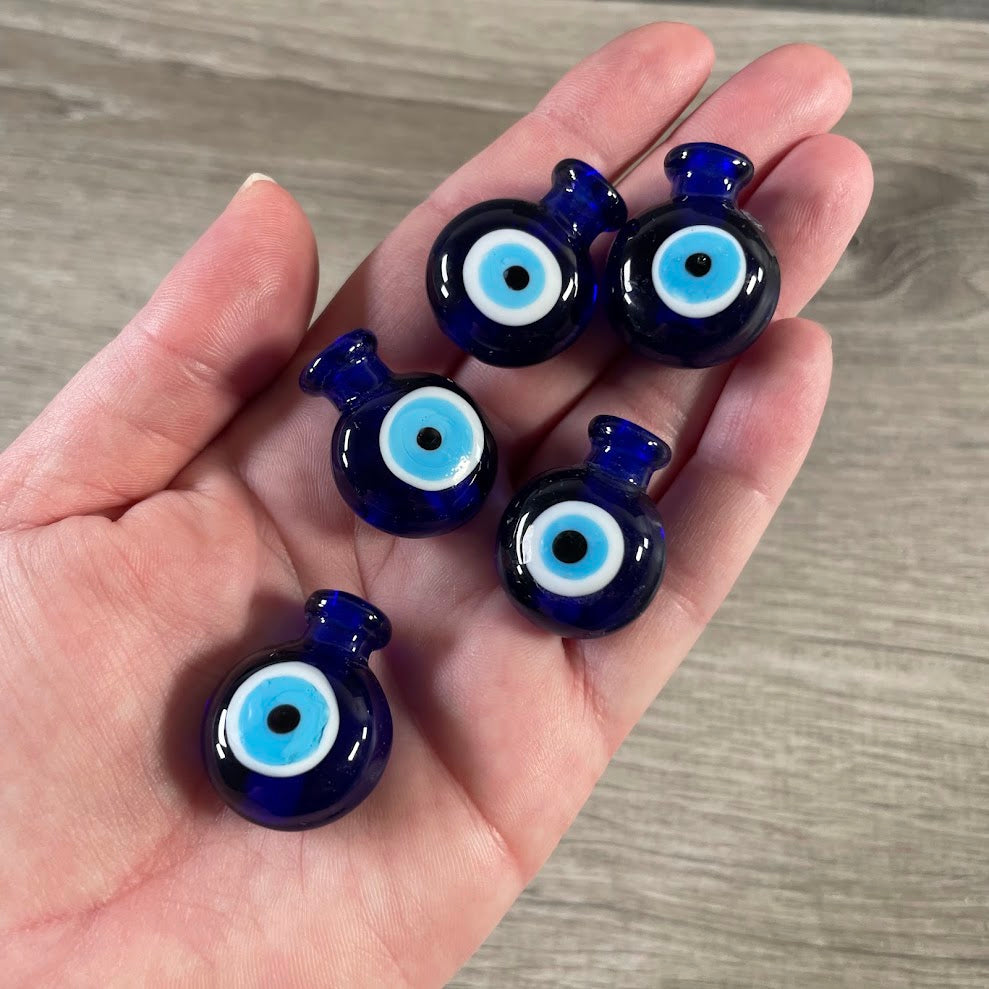 Decorative blue glass fragrance bottle featuring an evil eye motif.