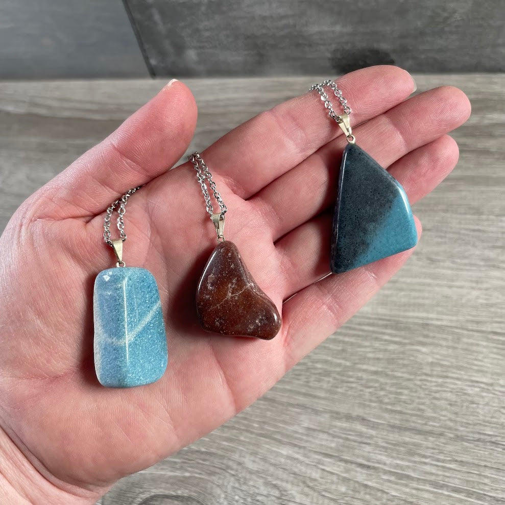 Assorted natural tumbled stone pendants from Brazil on stainless steel necklace chains