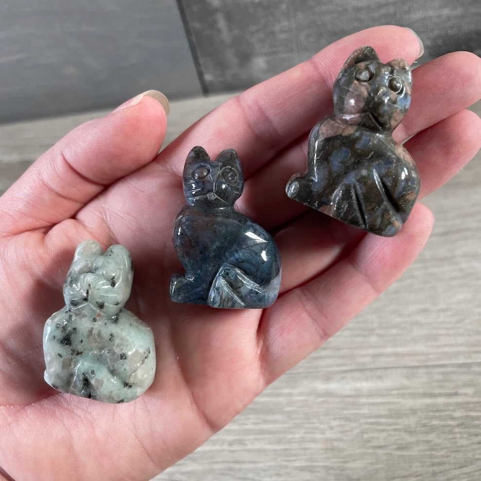 Assorted gemstone cat figurines carved from natural crystals for wholesale retail displays.