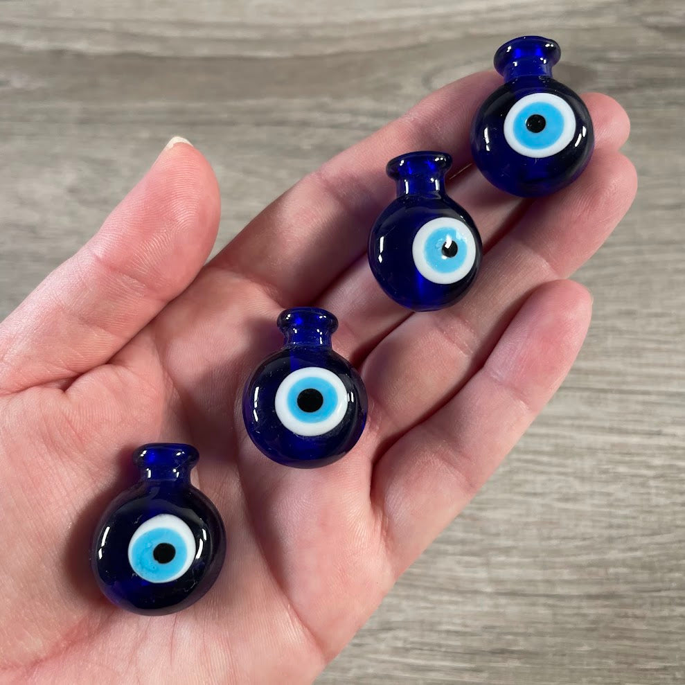 Blue glass perfume bottle with evil eye detail for a vanity display.