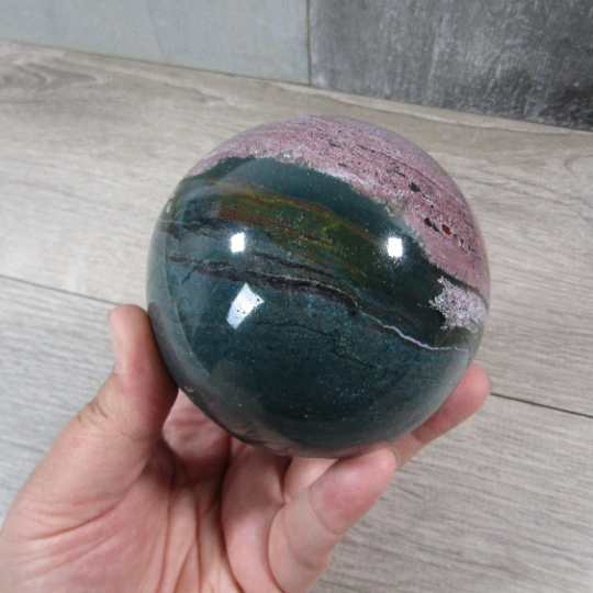 Natural ocean jasper sphere showcasing green, and pink tones