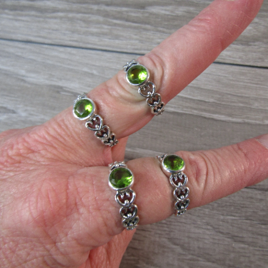 Sterling Silver ring with the band made connected hearts with a round peridot center stone