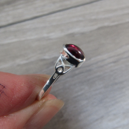 Sterling silver ring with celtic trinity knot band and garnet center stone