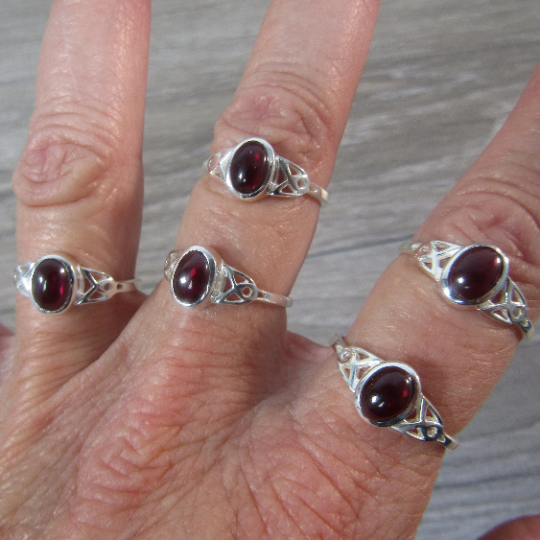 Sterling silver ring with celtic trinity knot band and garnet center stone