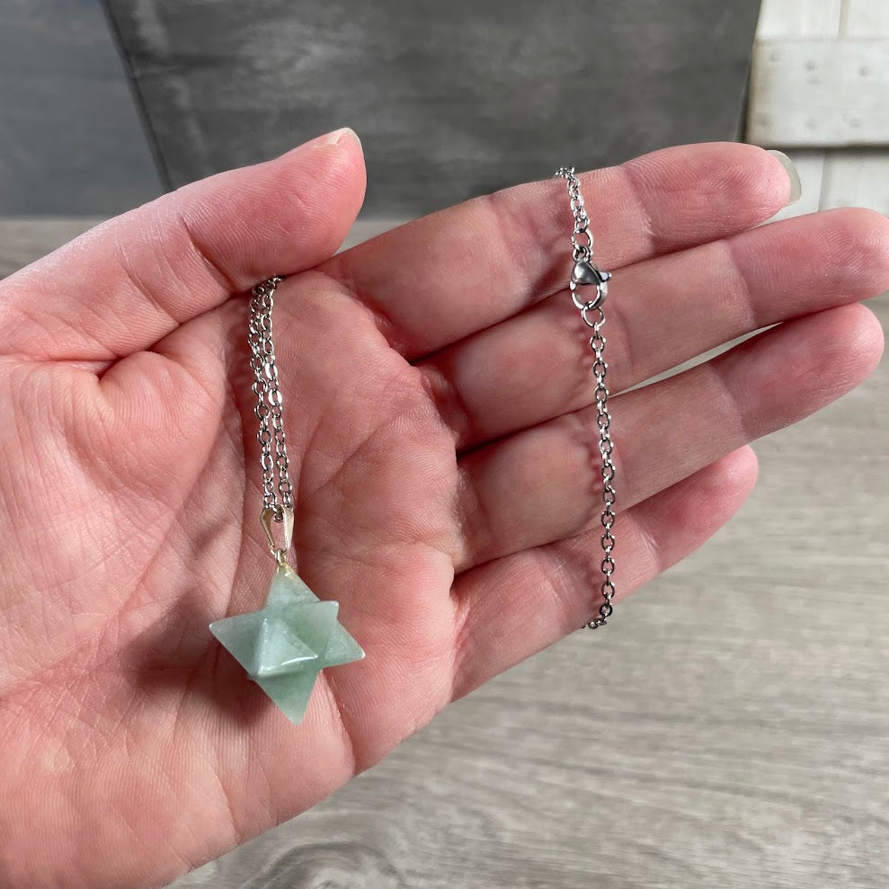 Close-up of carved green aventurine Merkaba star gemstone pendant