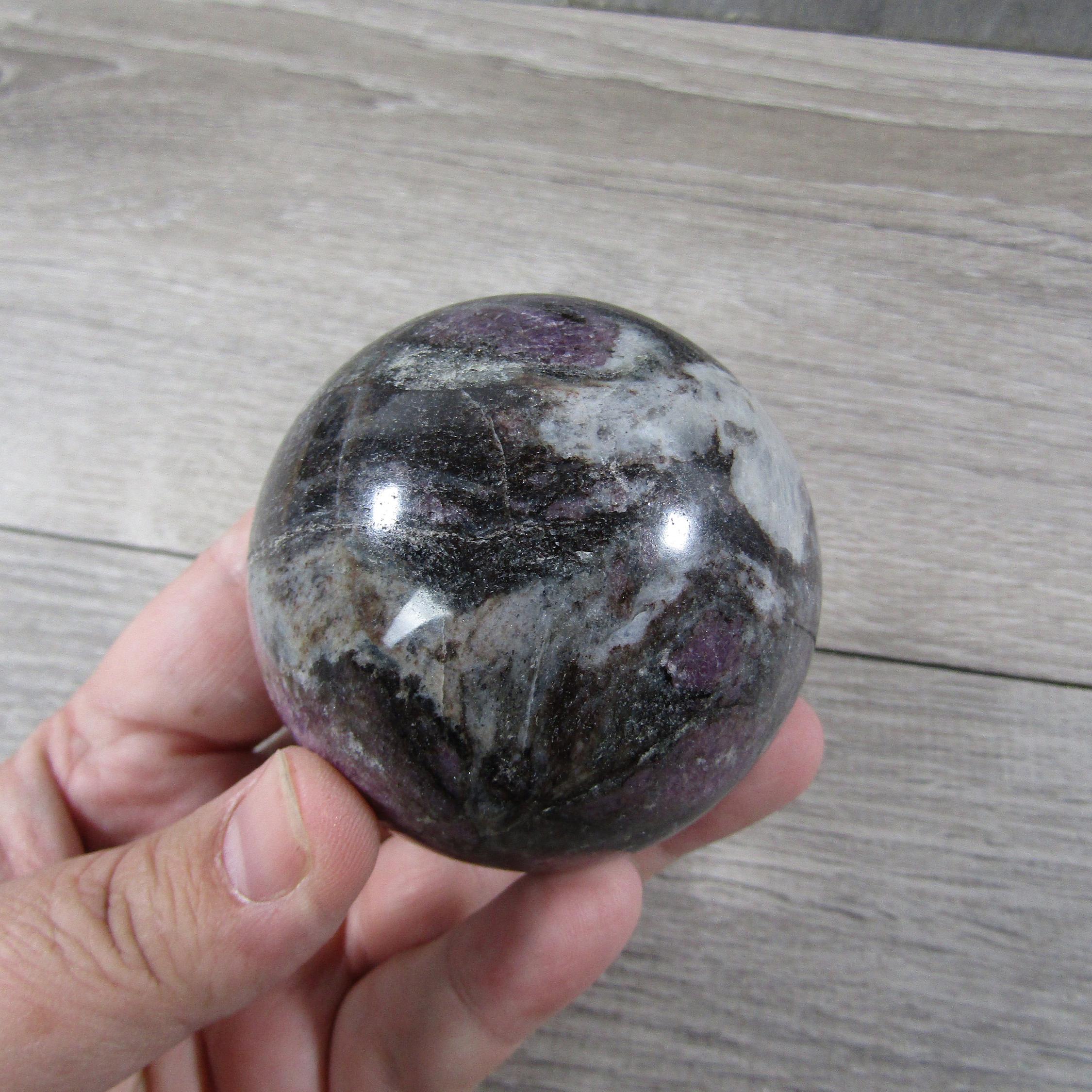 Large spinel display sphere with deep ruby red hues on a black velvet background