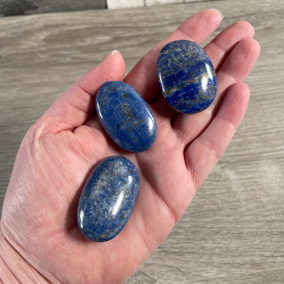 Polished lapis lazuli stones showing natural golden pyrite inclusions