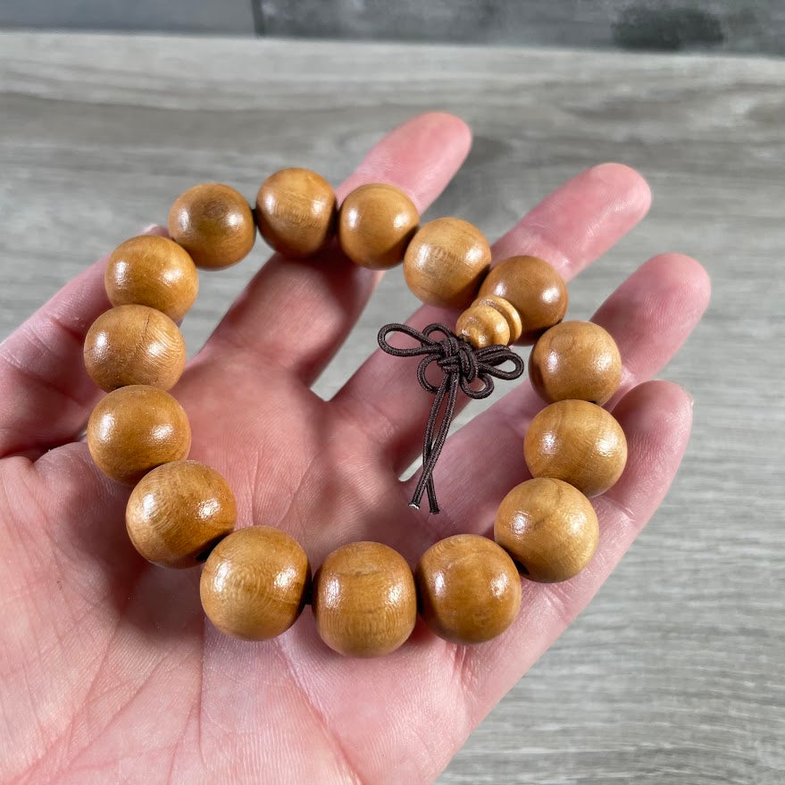 Wood mala bead bracelet with natural earthy tones for yoga studios and metaphysical retailers