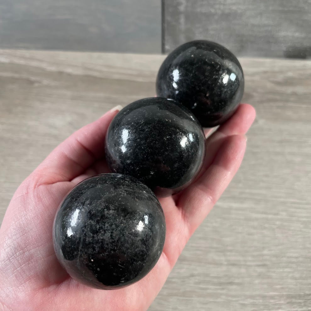 Natural nuummite crystal ball with black and golden flash tones