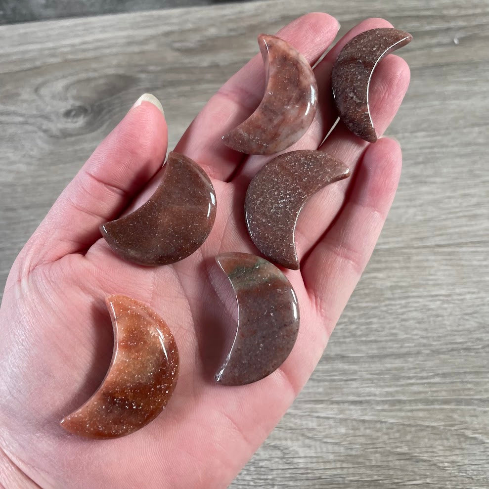 Red aventurine hand carved Brazilian gemstone moon showing its curved shape
