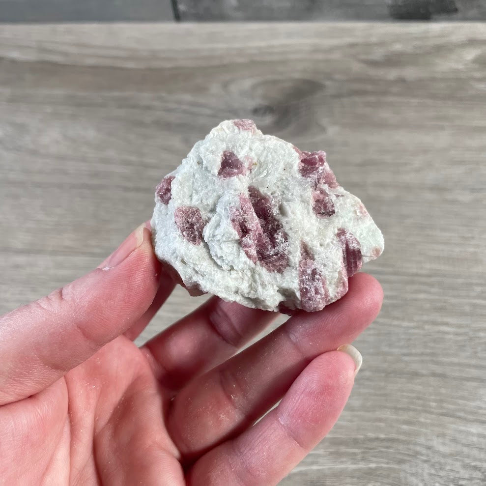 Rough gemstone specimen with pink tourmaline in quartz