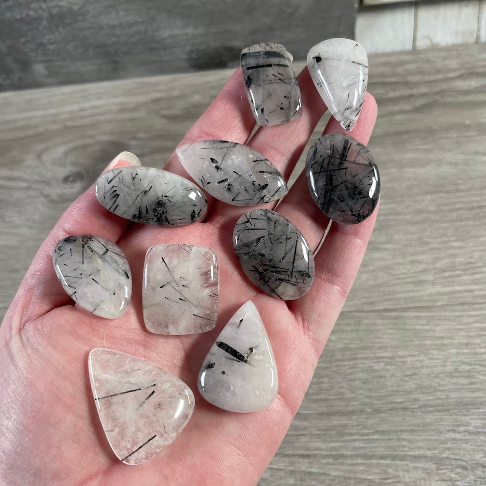 Tourmalinated quartz polished stone cabochons in natural crystals