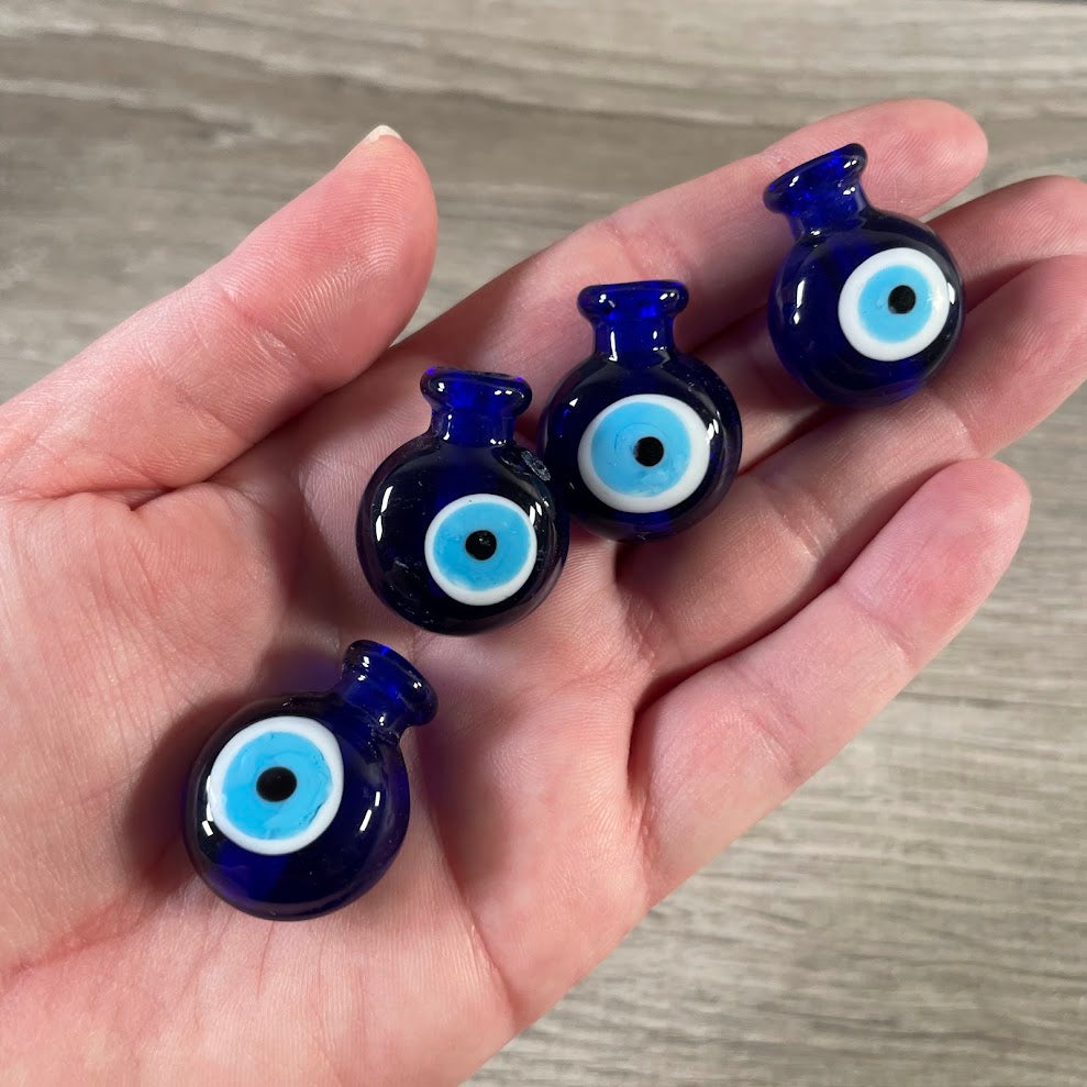 Blue glass evil eye perfume bottle with decorative eye design.