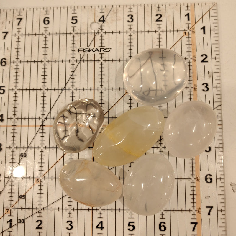 Clear Quartz and Smoky Quartz on a ruler grid.